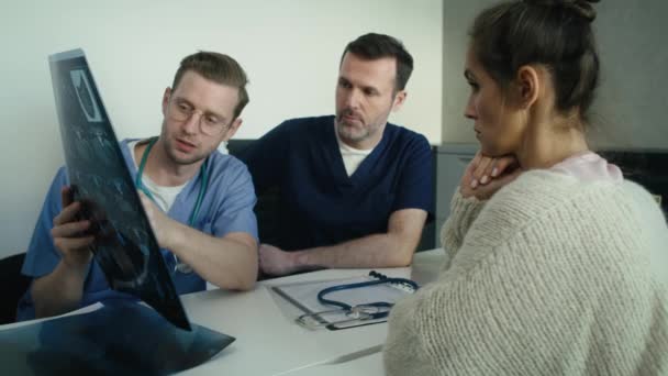Zwei Kaukasische Ärzte Diskutieren Mit Einer Patientin Über Medizinische Röntgenuntersuchungen — Stockvideo