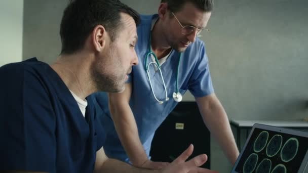 Két Fehér Férfi Orvos Oldalnézete Amint Orvosi Röntgenfelvételen Beszélgetnek Laptopon — Stock videók