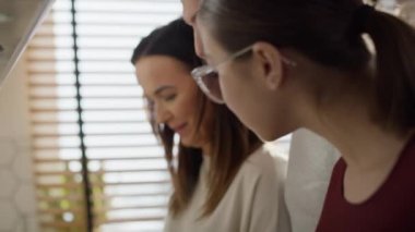 Üç kişilik beyaz bir aile birlikte yemek pişiriyor. 8K 'da kırmızı helyum kamerayla çekildi.. 