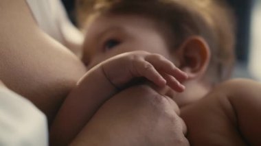 Annesi tarafından emzirilen Asyalı bebeğin seçici odağı. 8K 'da kırmızı helyum kamerayla çekildi..  