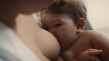 Annesi tarafından emzirilen Asyalı bir bebek. 8K 'da kırmızı helyum kamerayla çekildi.. 