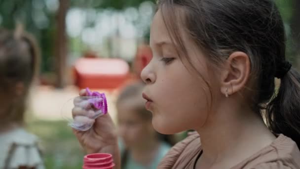 Beyaz Kız Parkta Sabun Köpüğü Üflüyor Kırmızı Helyum Kamerayla Çekildi — Stok video