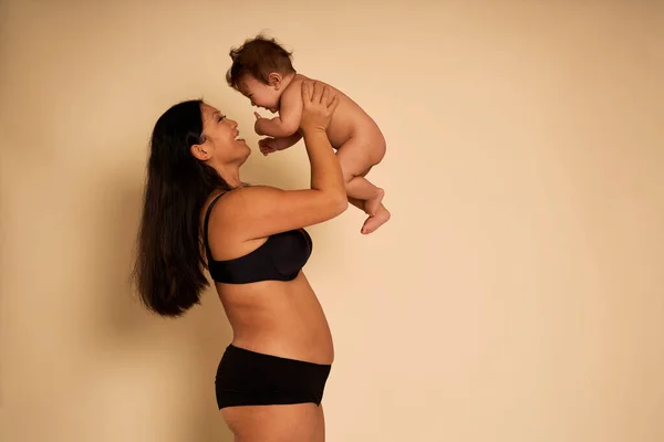 アジアの女性で下着頭の上に幼児を保持 — ストック写真