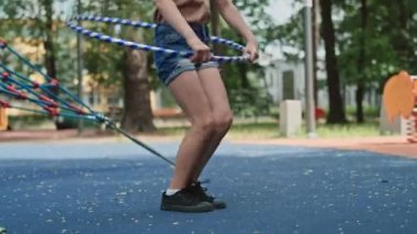 Caucasian girl playing with plastic hop at the playground. Shot with RED helium camera in 8K.  