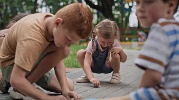 Ομάδα Καυκάσιων Παιδιών Χρωματίζουν Κιμωλία Την Καλοκαιρινή Μέρα Στο Πάρκο — Αρχείο Βίντεο