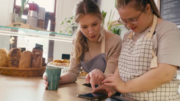 Девушка Синдромом Дауна Просматривает Телефон Вместе Своим Коллегой Кафе Съемка — стоковое видео