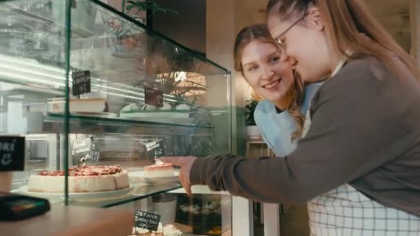 ケーキを選択するクライアントに助言ダウン症候群の女の子のズーム 8Kでレッドヘリウムカメラで撮影 — ストック動画