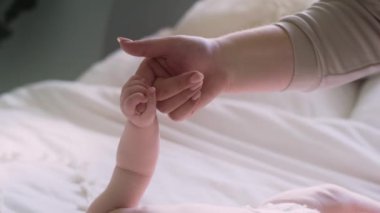 Bebeğin annesinin parmağını tutmasının ayrıntıları. 8K 'da kırmızı helyum kamerayla çekildi..     