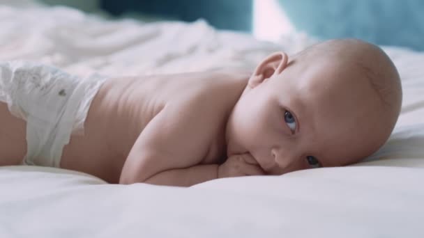 Novorozené Dítě Leží Vpředu Posteli Dívá Jinam Snímek Red Heliovou — Stock video