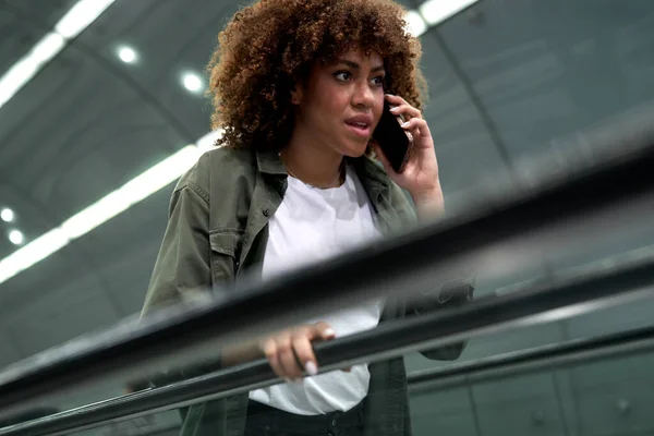 若いアフロ女性は地下鉄のエスカレーターで移動し 携帯電話で話す — ストック写真