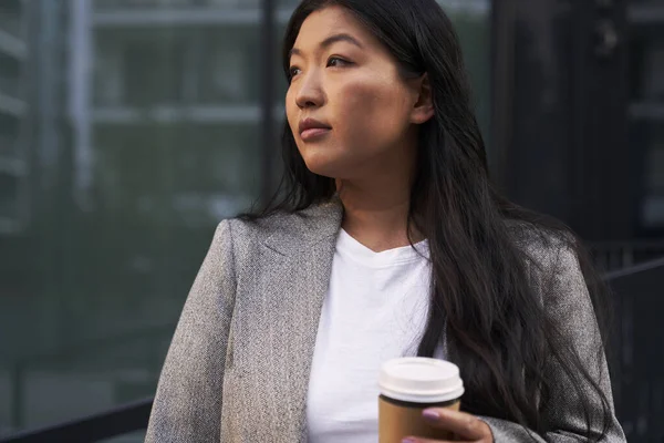 Biznes Chińska Kobieta Stoi Ulicy Filiżanką Kawy Odwracając Wzrok — Zdjęcie stockowe