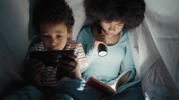 Dua Anak Menghabiskan Malam Bawah Selimut Dan Membaca Buku Atau — Stok Video