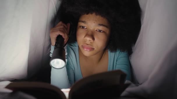 Έφηβη Κοπέλα Περνάει Νύχτα Κάτω Από Κουβέρτα Διαβάζοντας Βιβλίο Δαυλό — Αρχείο Βίντεο