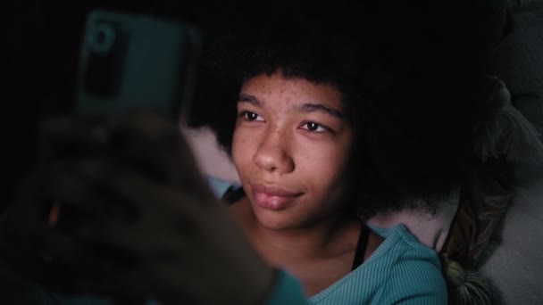 10代の女の子が1泊でリビングルームで携帯電話を閲覧 8Kでレッドヘリウムカメラで撮影 — ストック動画