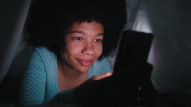 Fröhliches Teenager Mädchen Das Nachts Wohnzimmer Mit Dem Handy Surft — Stockvideo