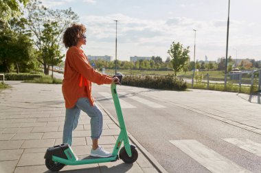 Elektrikli scooter kullanan siyah bir kadın.