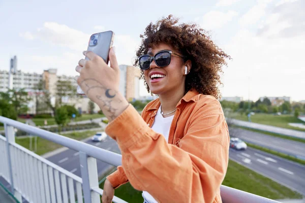Czarna Kobieta Okularach Przeciwsłonecznych Patrząc Telefon Komórkowy — Zdjęcie stockowe
