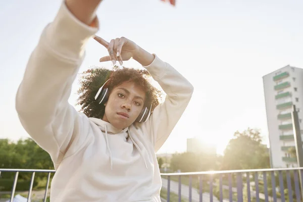 ヘッドフォンをして橋の上で踊る黒人女性 — ストック写真