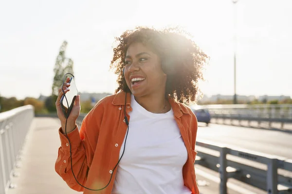 陽気黒の女性はヘッドフォンを着用し 橋の上で踊る — ストック写真