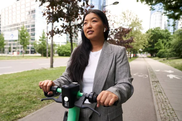 Chińska Kobieta Jazdy Skuterze Elektrycznym Stroju Biznesowym Noszenia Słuchawek — Zdjęcie stockowe
