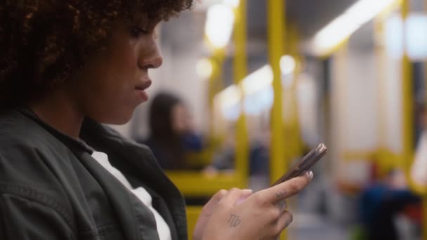 Widok Boku Młodej Afro Kobiety Podróżującej Metrem Przeglądającej Telefon Komórkowy — Wideo stockowe