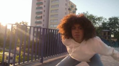 Siyah bir kadının köprüde dans edişinin düşük açılı görüntüsü. 8K 'da kırmızı helyum kamerayla çekildi..