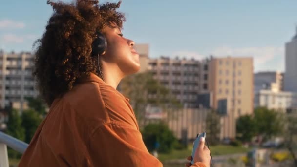 Black Woman Wearing Headphones Standing Bridge Shot Red Helium Camera — Stock Video