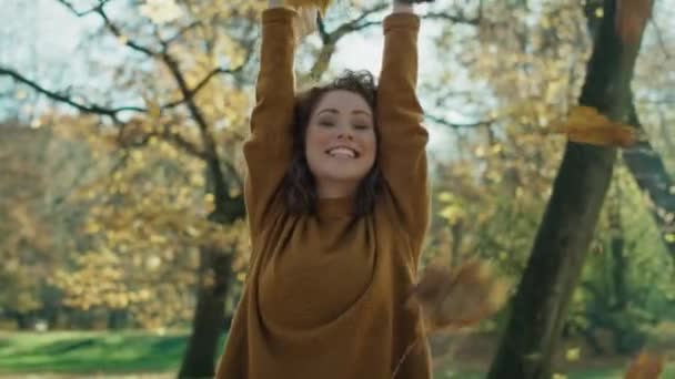 白人の生姜女が秋の葉を投げて天気を楽しむ 8Kでレッドヘリウムカメラで撮影 — ストック動画