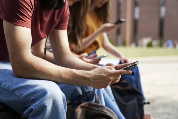 Невпізнавані Студенти Університету Переглядають Телефони Біля Будівлі Кампусу Університету — стокове фото