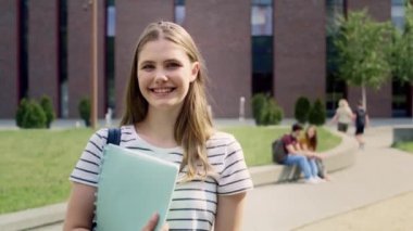 Üniversite kampüsünün dışında duran kız üniversite öğrencisinin portresi. 8 'de kırmızı helyum kamerayla çekildi.