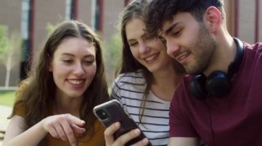Üniversite kampüsünün yanındaki telefona bakan bir grup öğrenci. 8K 'da kırmızı helyum kamerayla çekildi.. 