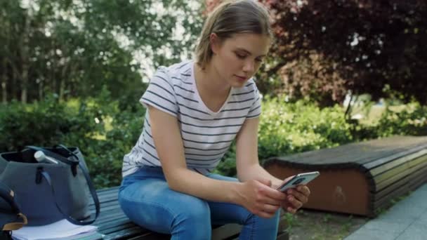 Blanke Vrouwelijke Student Browsen Mobiele Telefoon Buiten Opgenomen Met Red — Stockvideo