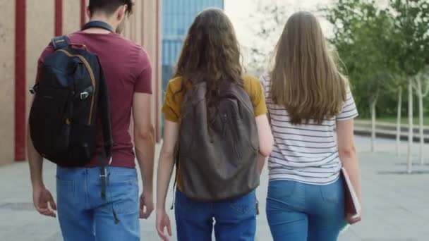 Powiększ Widok Trzech Białych Studentów Przechodzących Przez Kampus Uniwersytecki Nakręcony — Wideo stockowe