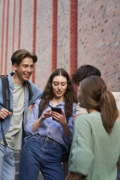 Üniversite Öğrencileri Üniversite Kampüs Binasının Yanındaki Telefona Bakıyorlar — Stok fotoğraf