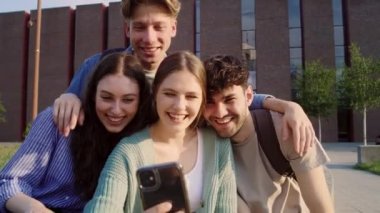 Bir grup beyaz öğrenci üniversite kampüsünün dışında selfie çekiyor. 8K 'da kırmızı helyum kamerayla çekildi..  