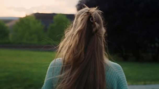 白人の若い女性が公園を歩いてカメラに向かっている 8Kでレッドヘリウムカメラで撮影 — ストック動画