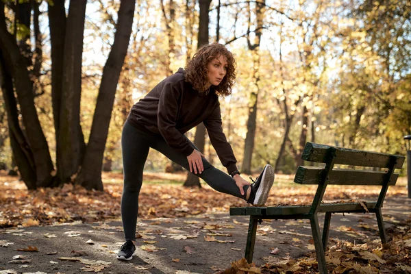 Pełna Długość Ruda Kobieta Rozciągająca Się Ławce Przed Jogging Parku — Zdjęcie stockowe