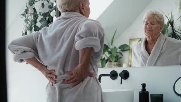 バスルームの高齢の白人女性は 強い腰痛を抱えています 8KでRedヘリウムカメラで撮影する — ストック動画