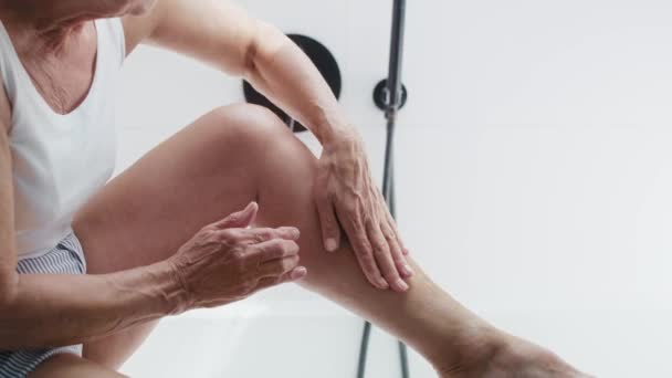 Unrecognizable Senior Woman Applying Moisturizing Cream Legs Shot Red Helium — Stock Video