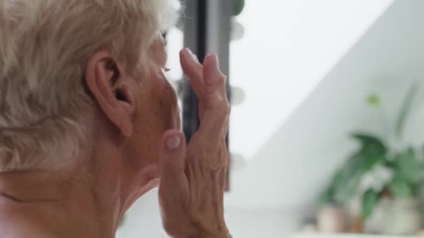 Senior Kvinna Väg Att Applicera Ögonkräm Skjuten Med Red Heliumkamera — Stockvideo