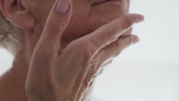 Chiudi Donna Anziana Che Applica Una Crema Viso Sul Collo — Video Stock
