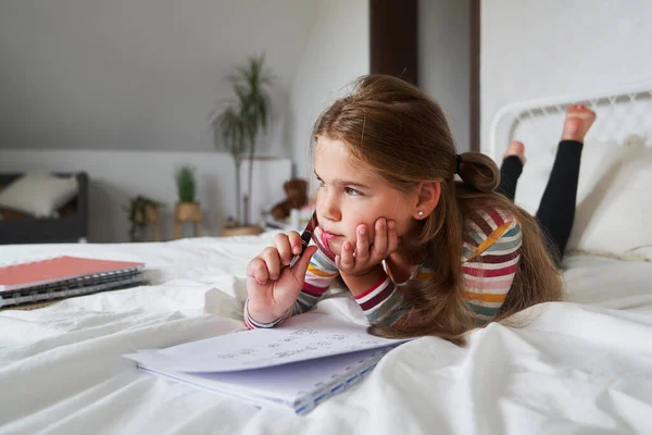 Elementary Age Girl Studying While Lying Front Bed — Stock Photo, Image