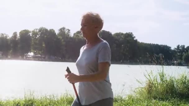 Senior Woman Practicing Nordic Walking Park Shot Red Helium Camera — Stock Video