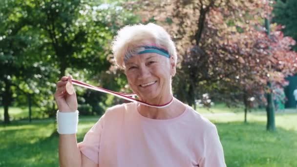 Portrait Senior Woman Celebrating Victory Golden Medal Shot Red Helium — Stock Video