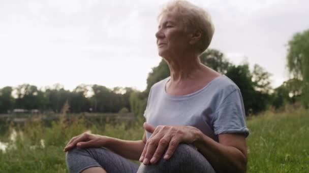 Ruhige Seniorin Meditiert Park See Aufnahme Mit Roter Heliumkamera — Stockvideo