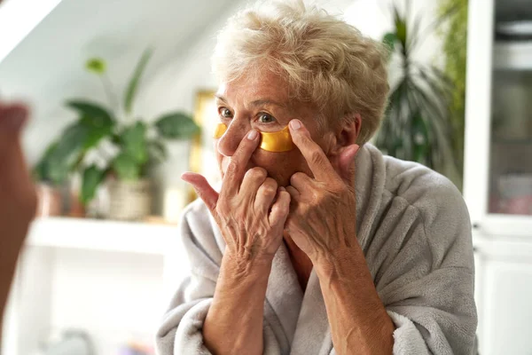 Starsza Kaukaska Kobieta Przykleja Przepaskę Oko Łazience — Zdjęcie stockowe