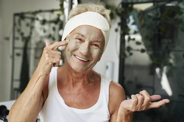 Glada Äldre Kvinna Som Tillämpar Kosmetisk Ansiktsmask — Stockfoto