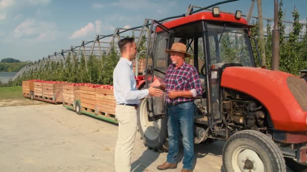 Kıdemli Çiftçi Elma Bahçesindeki Satış Temsilcisi Arasında Olumlu Bir Alışveriş — Stok video