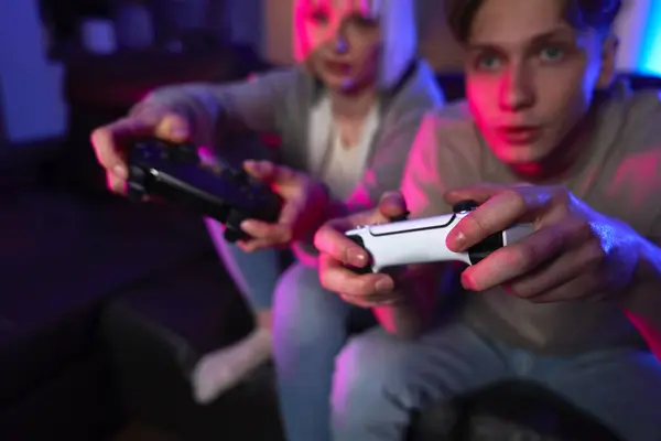 Close up of young caucasian couple playing video game with game pads