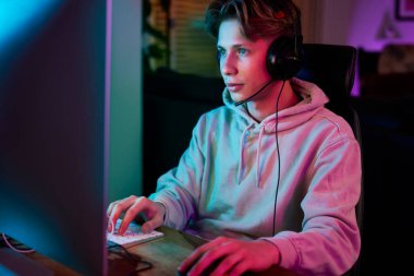 Beyaz adam neon ışıklarının arasında gece oyun oynuyor.